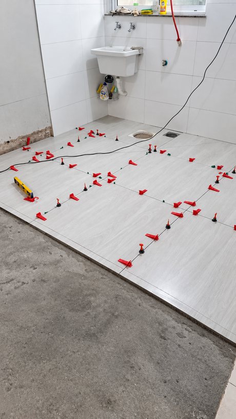 Área de serviço com metade do piso em porcelanato assentado e metade em contrapiso